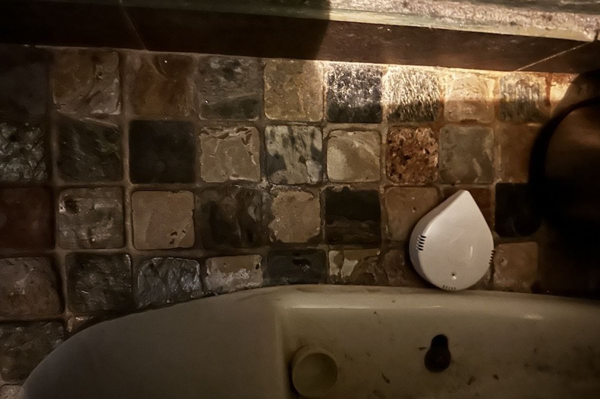 a photo of Moen Smart Leak Detector installed on the floor next to a toilet