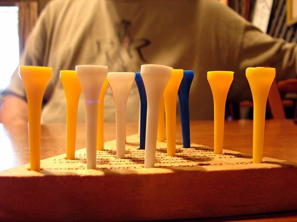 Yellow and blue pegs in a wooden pyramid board