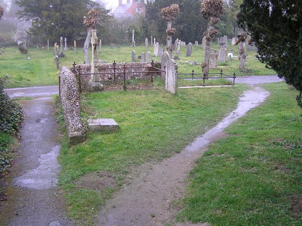 A dirt path cutting through graveyard