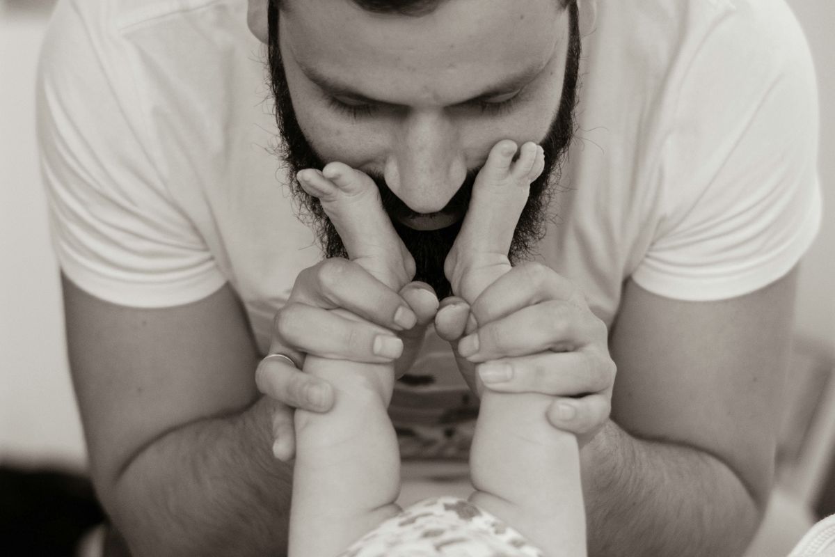 grayscale photography of man playing with baby