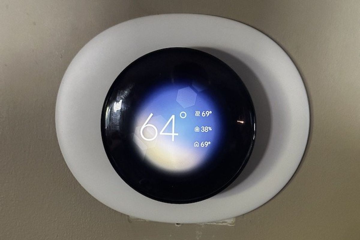 a photo of Nest Learning Thermostat 4th Gen on the wall wiith glare