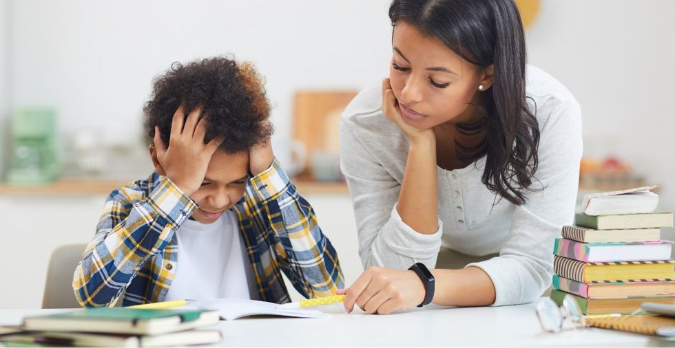boy studying, holding his head in his hands