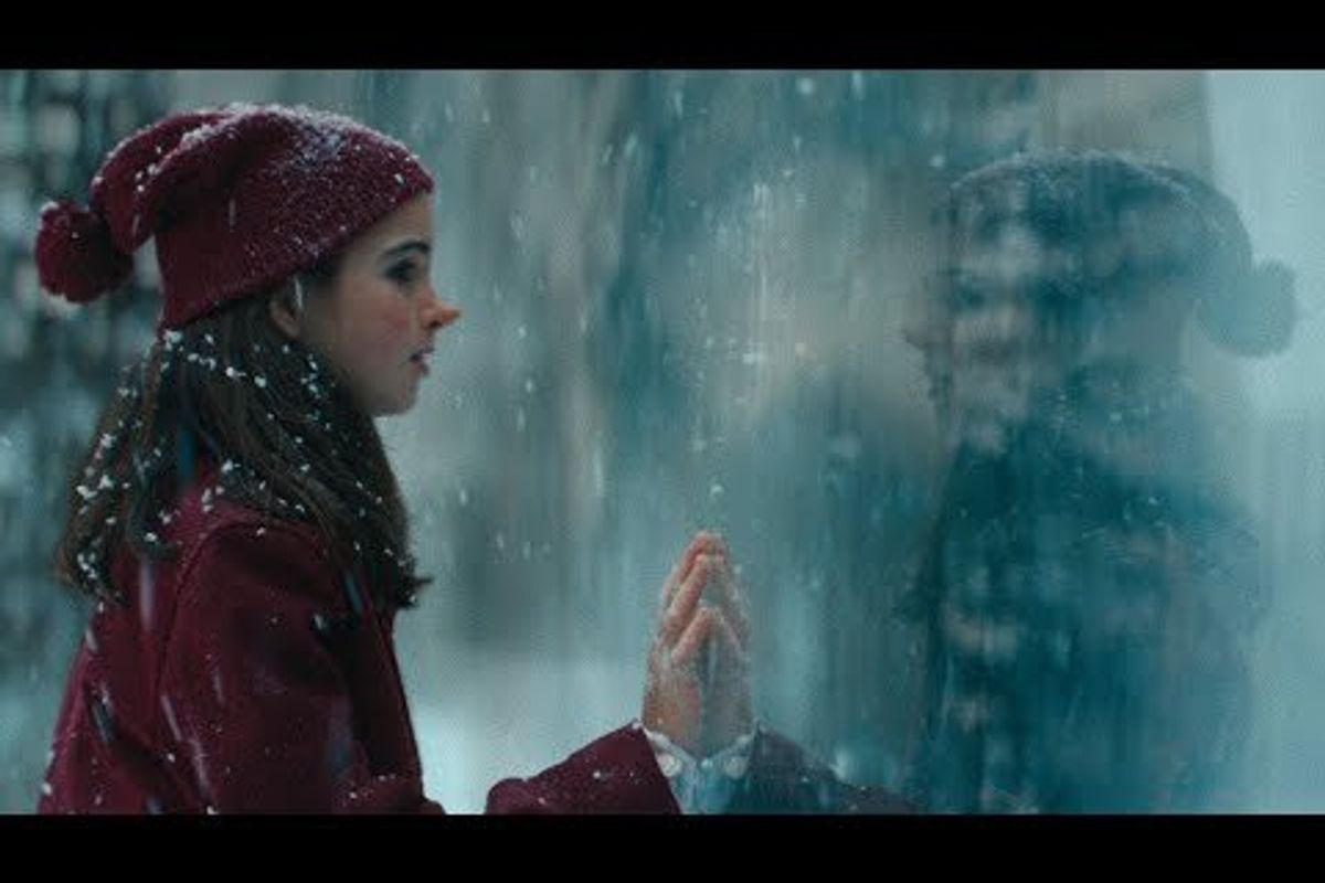 girl touching a glass wall in the snow
