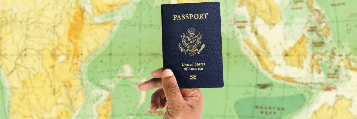 a hand holding a passport over a map