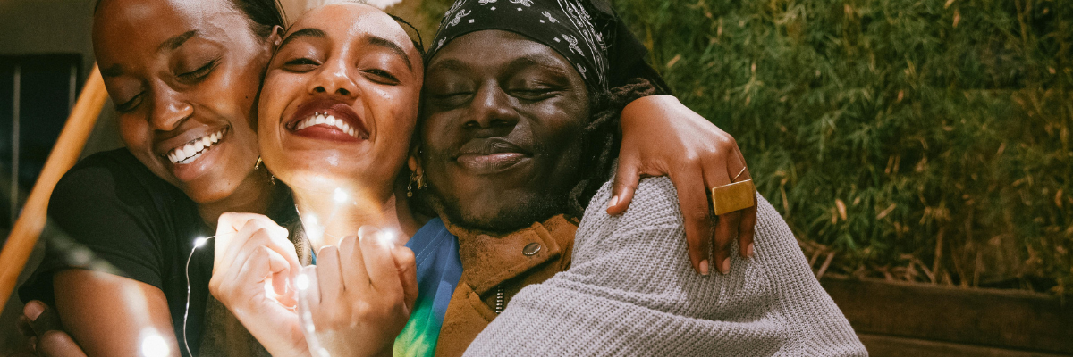 three happy friends embracing