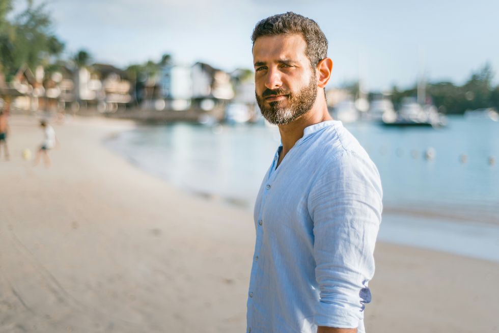 40s man standing on beach during daytime