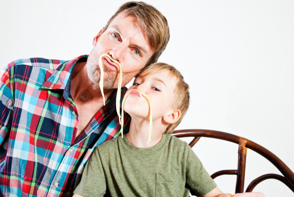 Father and son wearing noodles as mustaches
