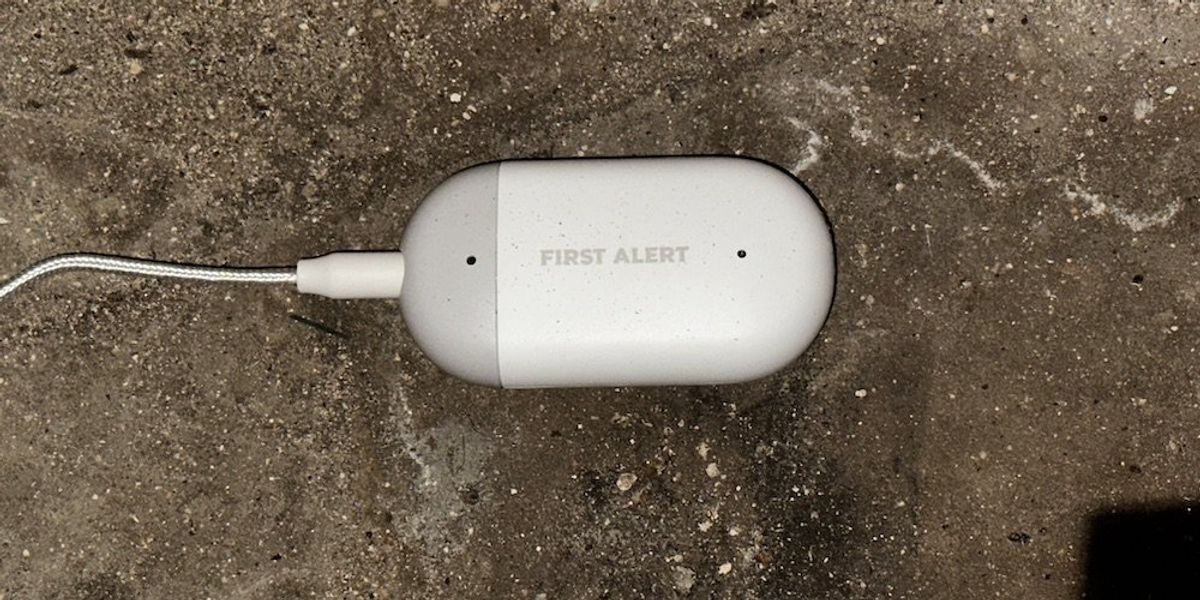 a photo of First Alert L1 WiFi Water Leak Detector installed on a basement floor