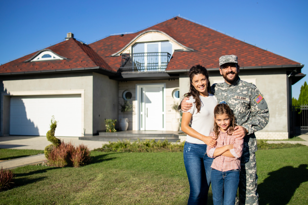 Veteran with wife and child in front of a house
