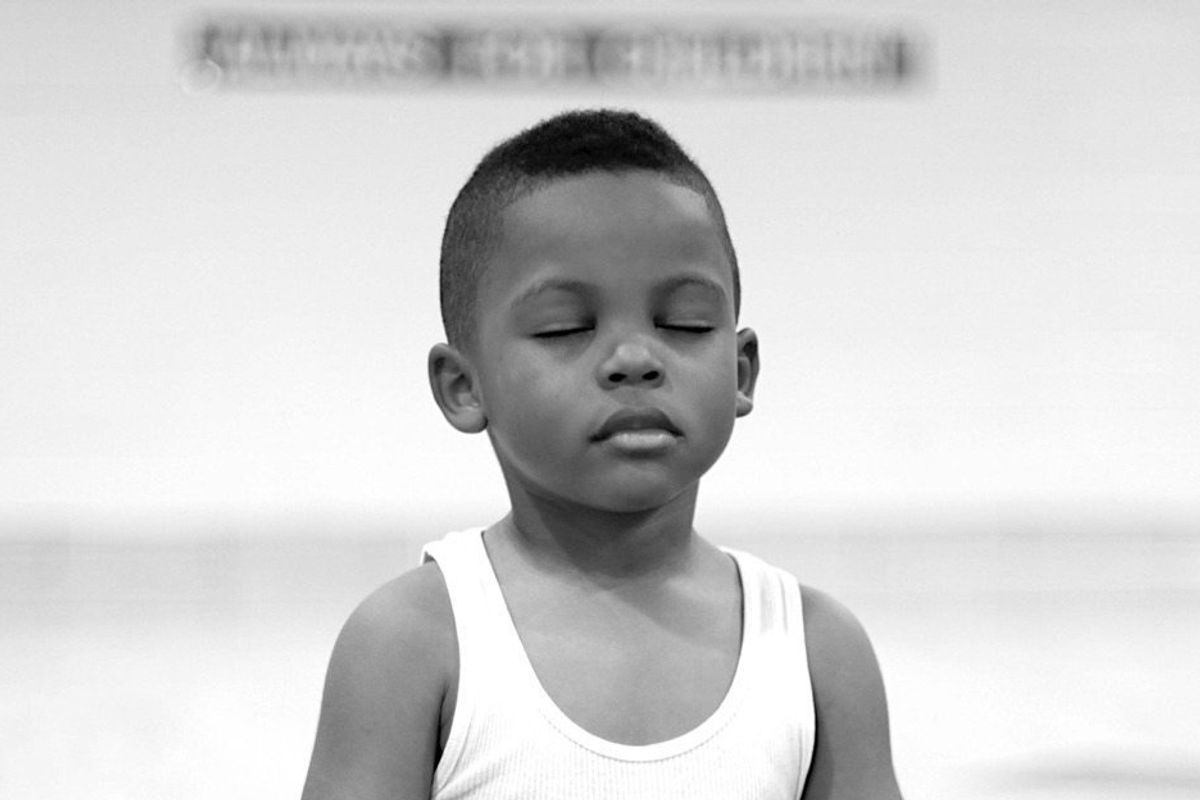 Young Black boy stands with eyes closed