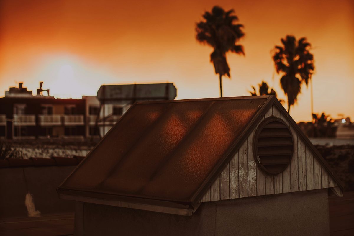 A picture of a house with a red sky in the background