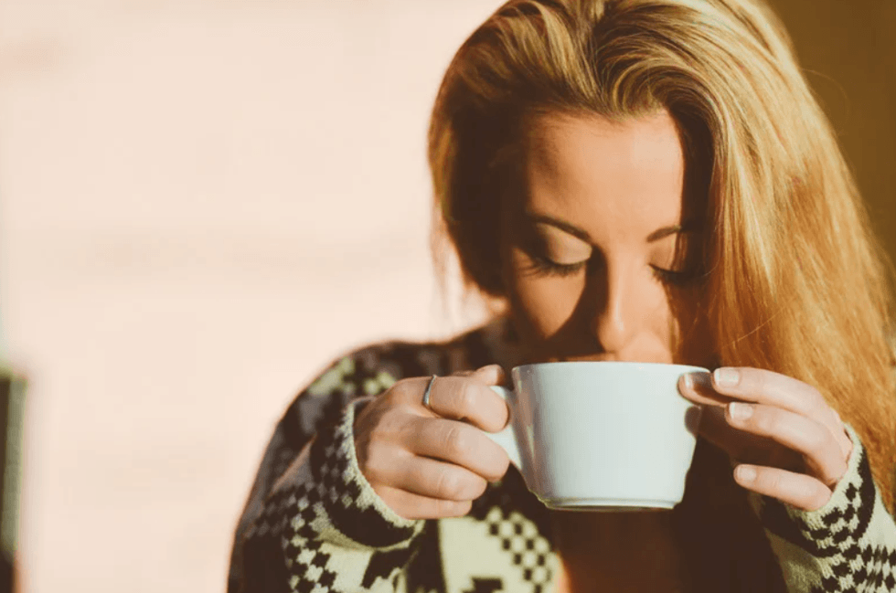 A woman sipping coffee alone.