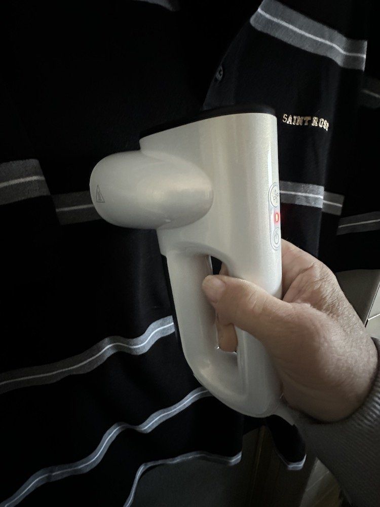 a photo of Neakasa Magic Vacuum Steamer steaming a shirt