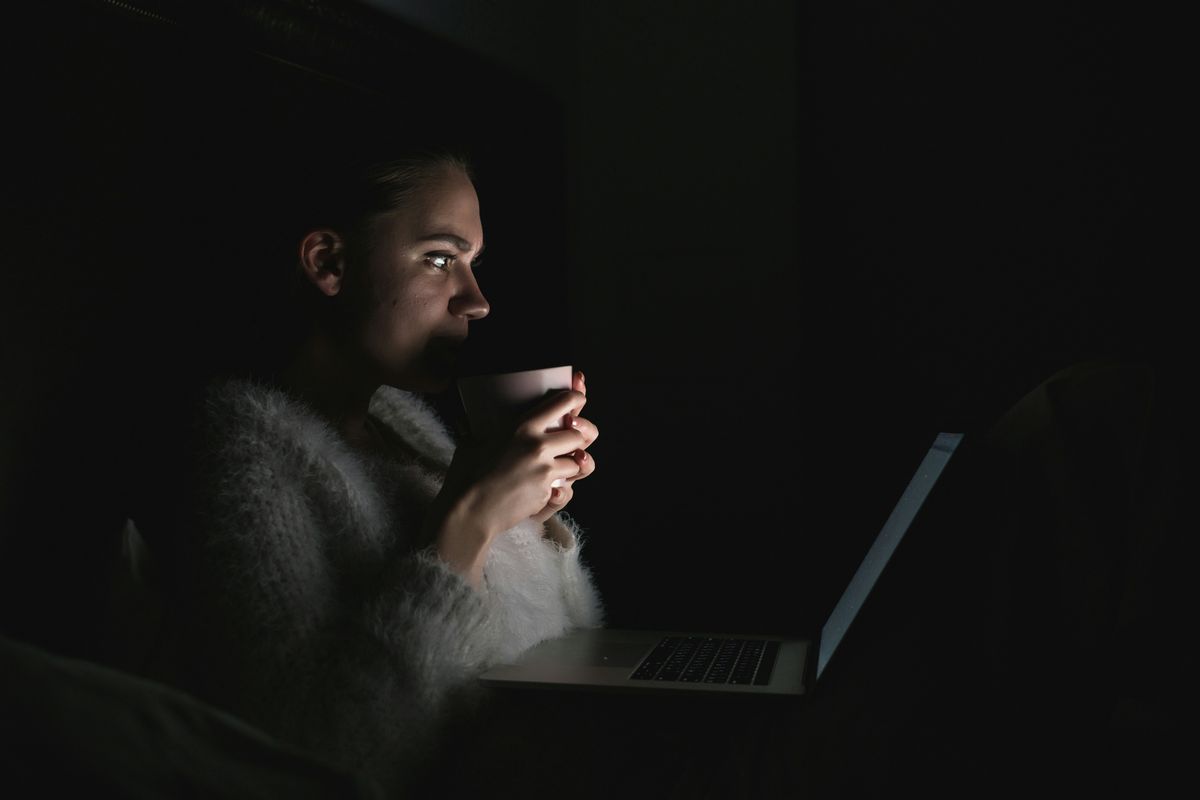 A person sits in front of a laptop