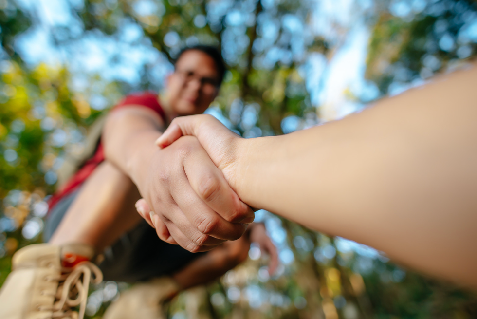 Person offering their hand to lift someone up