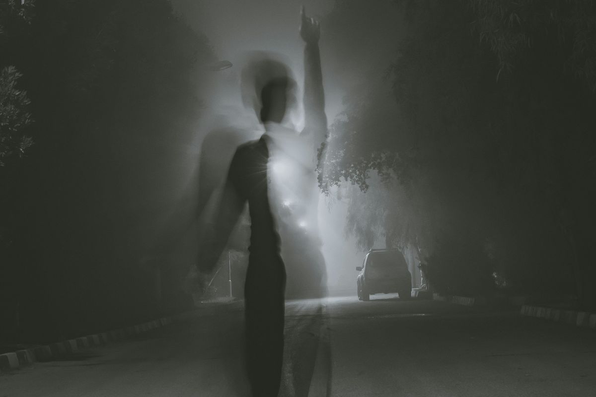 shadow of man standing at middle of road