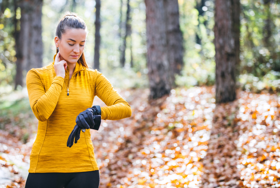 Woman checking her heart rate outside.