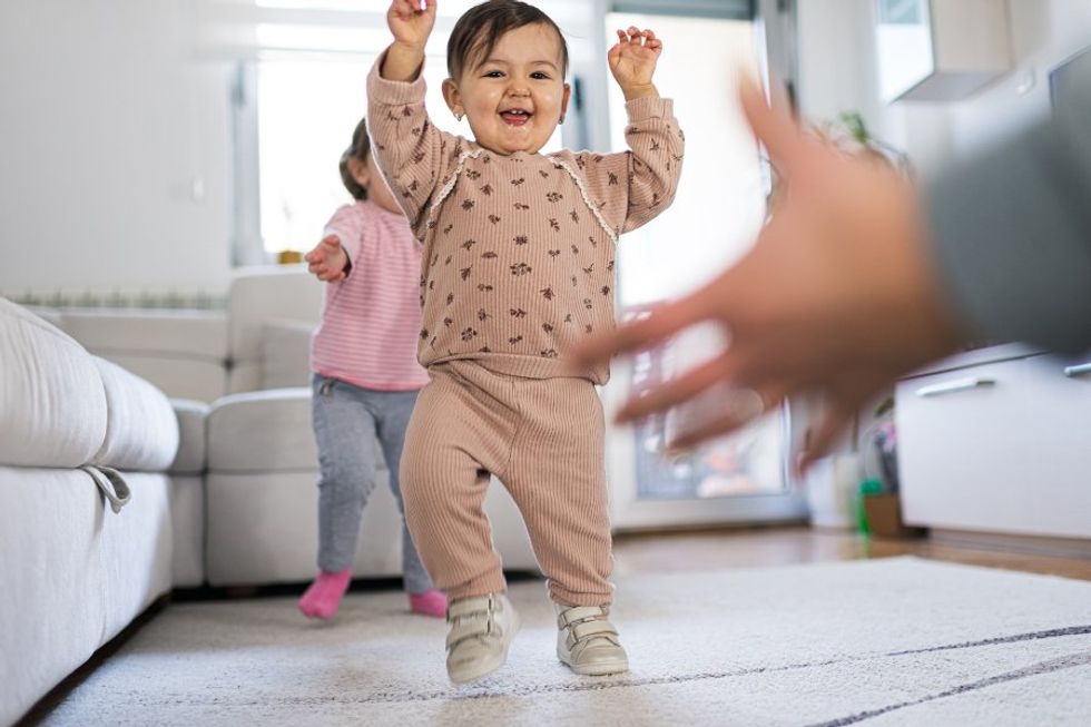 Daycare camera captures caregiver's wholesome excitement over baby's first steps