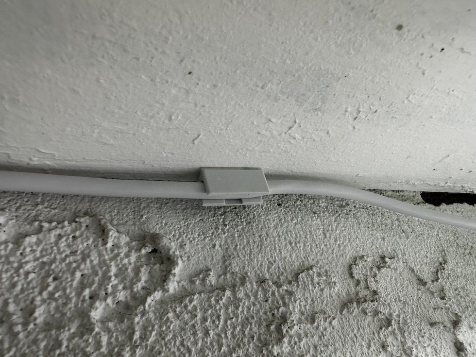 a photo of a clip securing the power cablet to SimpliSafe Outdoor Security Camera Series 2 with Active Guard