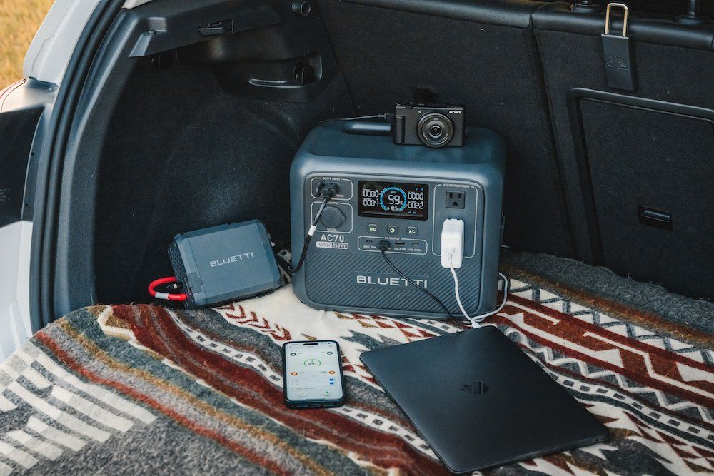 a photo of BLUETTI Charger 1 connected to a BLUETTI portable power station in the back of a SUV