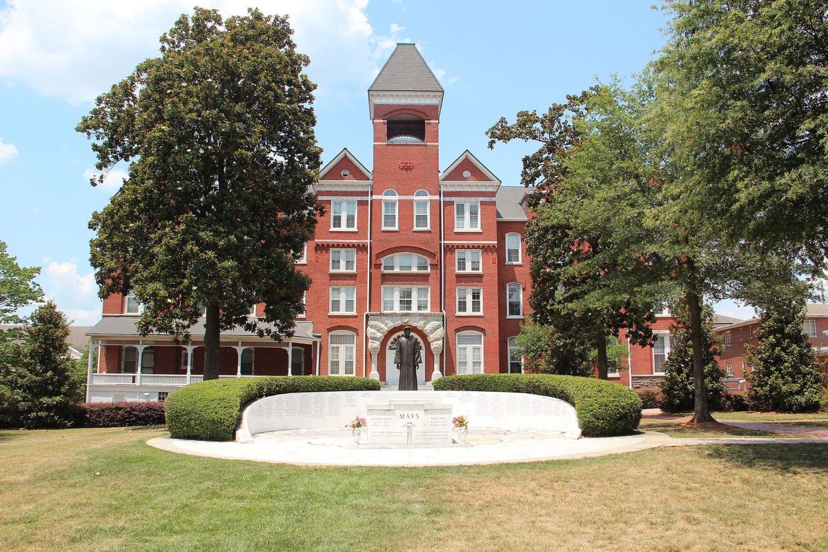 large red-brick building with trees and green lawn