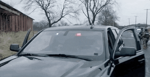 gif of man wearing FBI shirt getting out of dark car