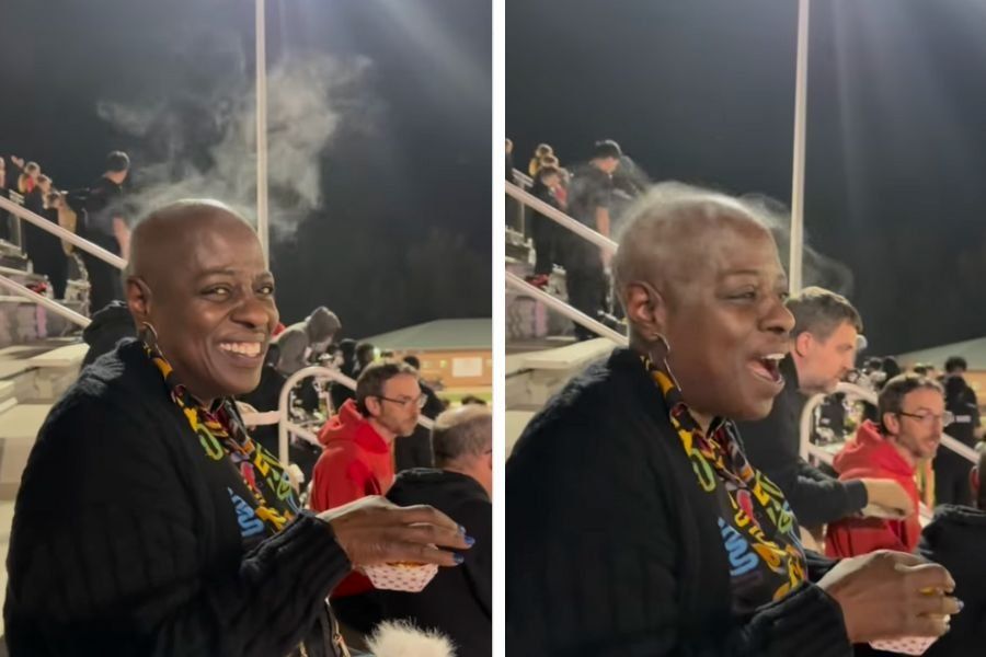 a bald woman sits outside at an evening event with visible steam coming off her head