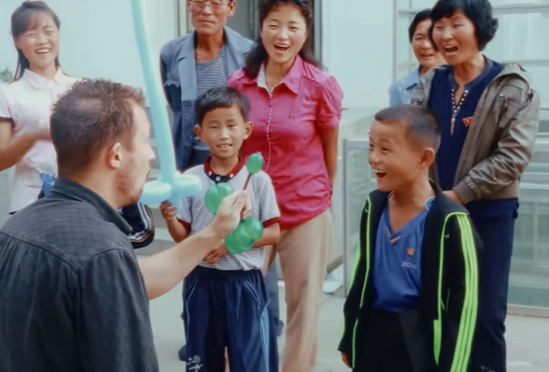 man performing a magic trick for young children 