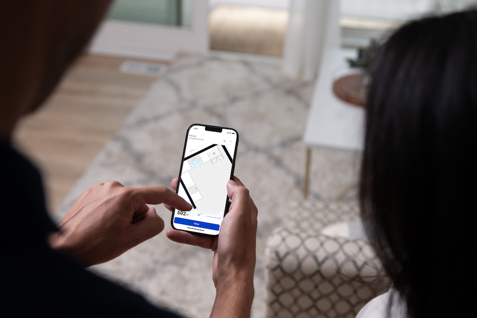 a photo of a person using Mylow on their smartphone to create a room in the app