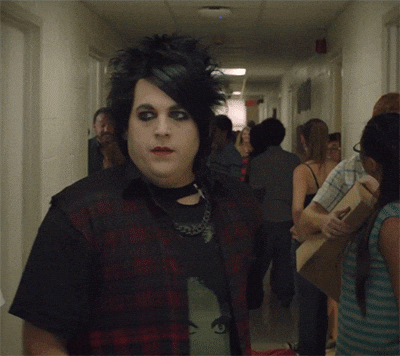 goth teen walking through school halls and flipping his hair