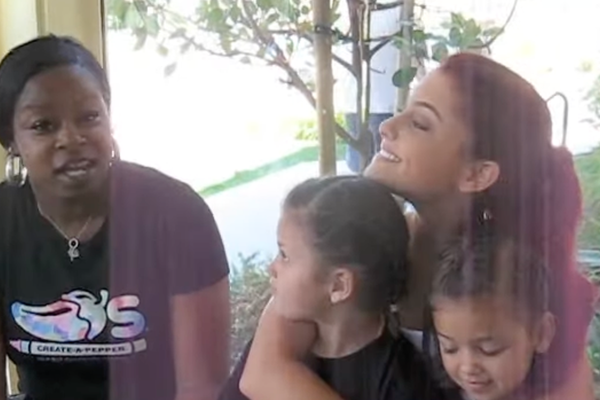 A younger Ariana Grande hugs two kids