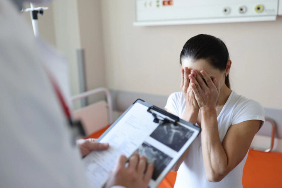 A woman hears bad news at the doctor's office.