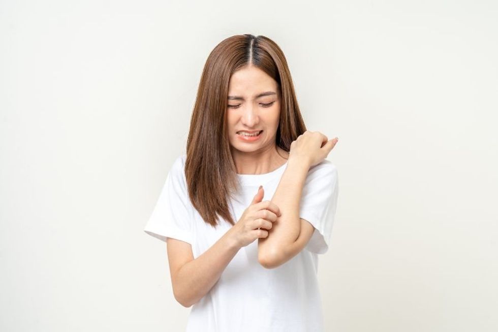 a woman scratching her arm