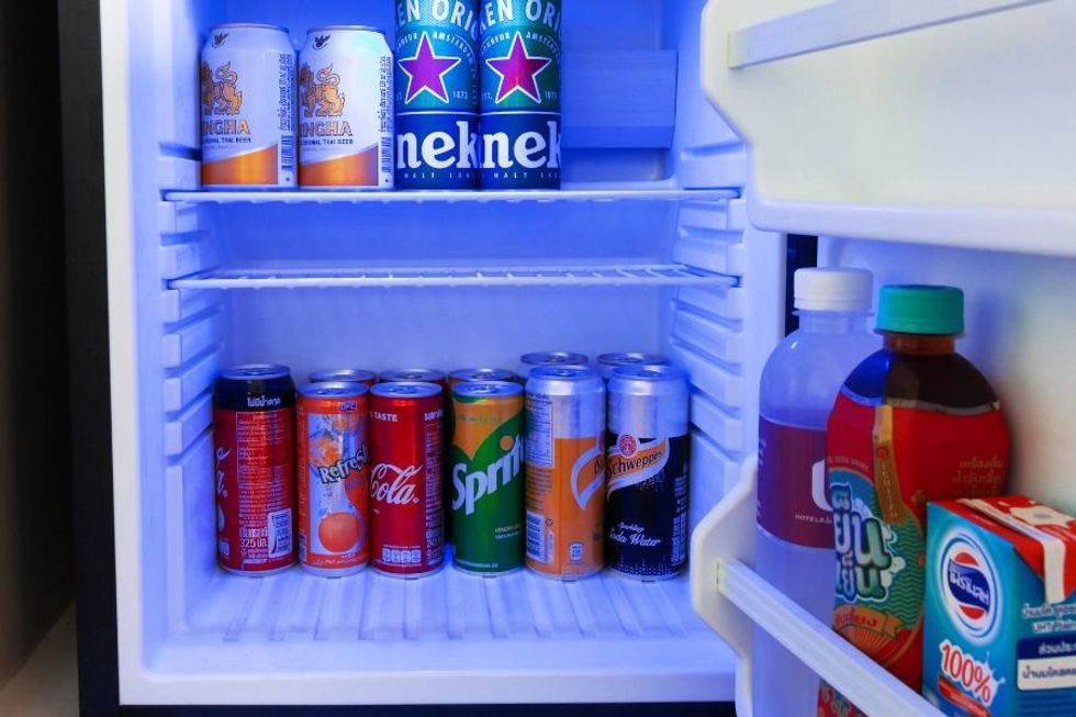open fridge filled with beer, soda, and juice
