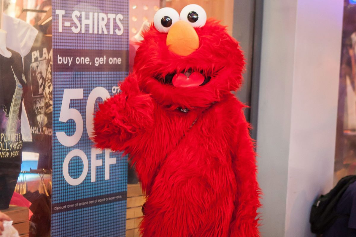 person dressed as Elmo poses for a photo