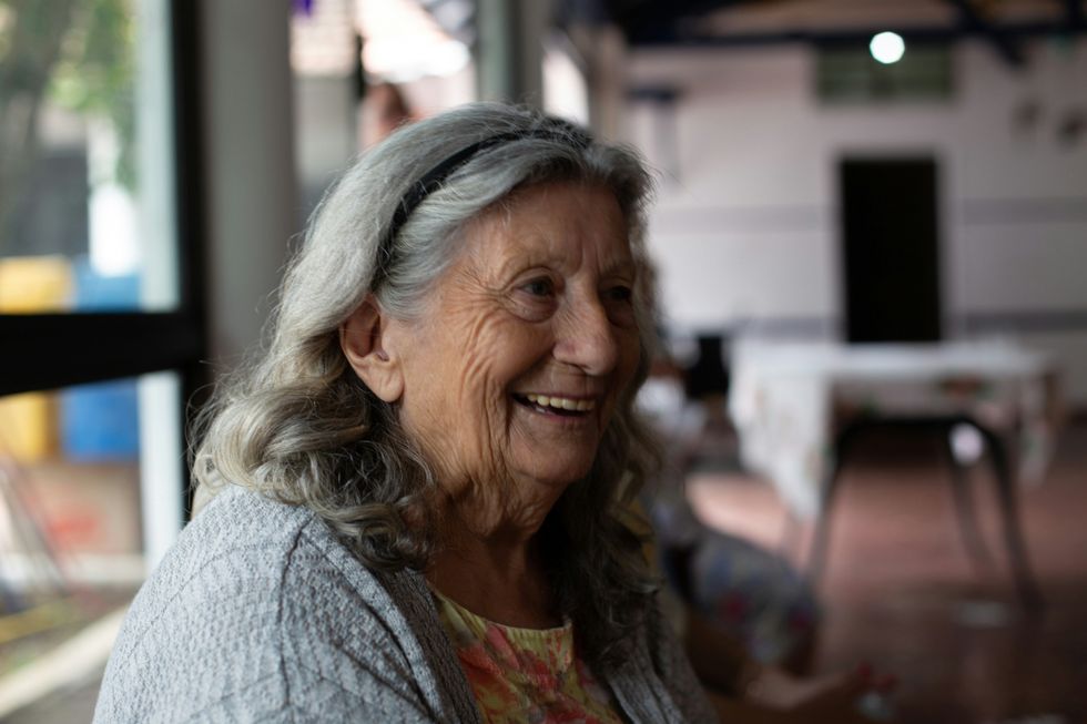 smiling woman in gray cardigan