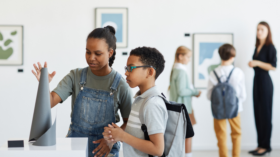 children standing next to art exhibit
