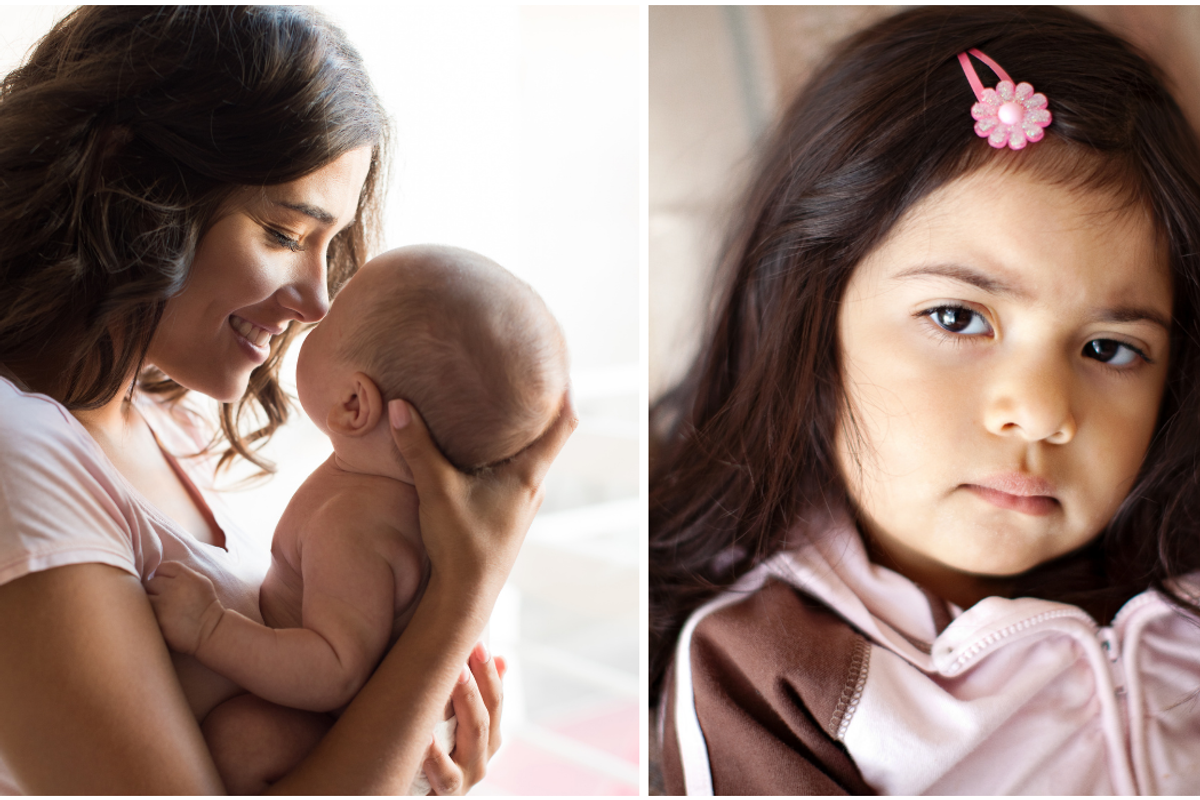 Adult woman cradling baby, sullen toddler