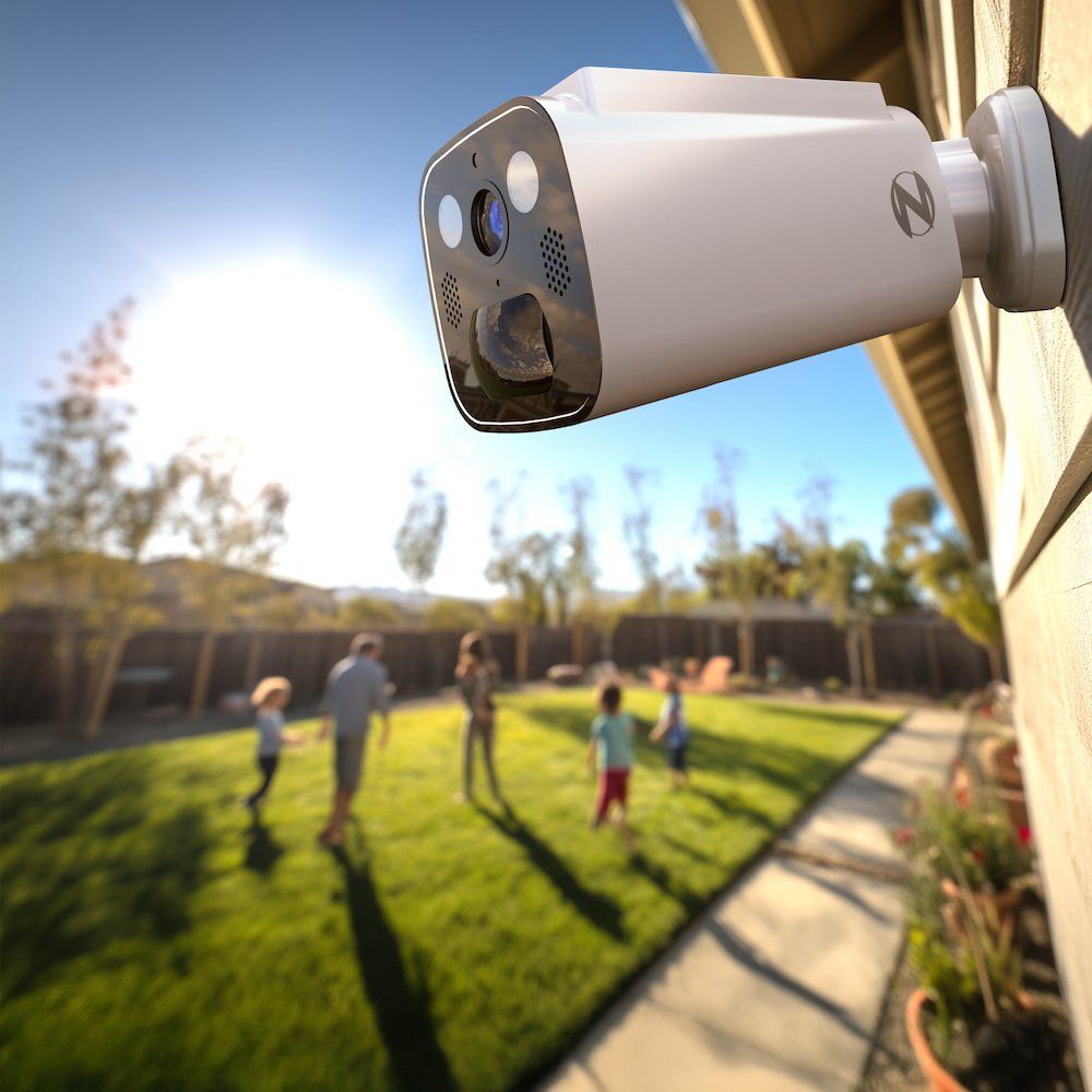 a photo of Night Owl's New Solar-Powered Security Camera on a home with a family playing in the yard.
