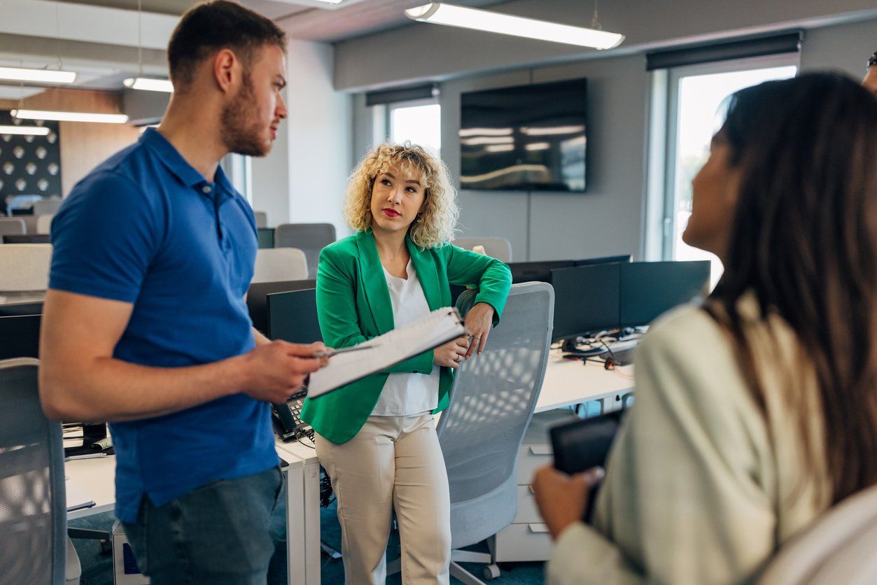 A group of co-workers are discussing a business project they are working on as a team. They stand in the meeting room and agree on the implementation of the business strategy stock photo