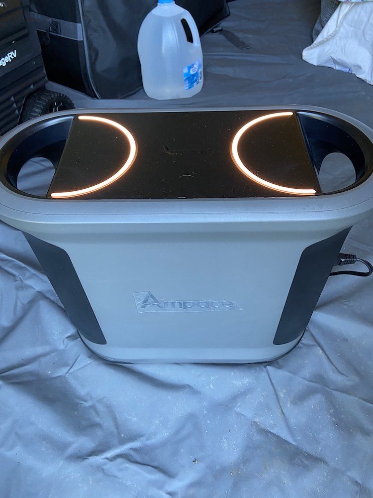 a photo of Ampace Andes 1500 in a tent powering up a inflattable mattress.