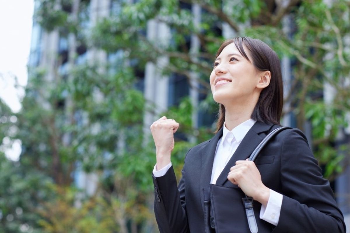 A confident woman in a suit, smiling with a fist pump, exuding confidence, confidence, body language