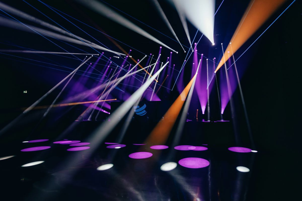 Colorful stage lights and laser beams in a dark room.