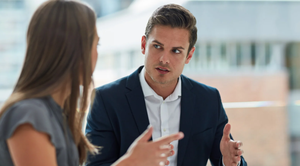 man and woman, man in suit, serious conversation, talking with hands, blonde man