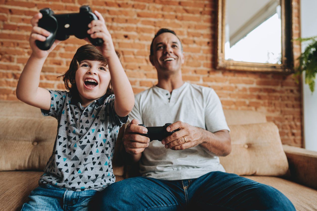 Father and son playing video games together stock photo