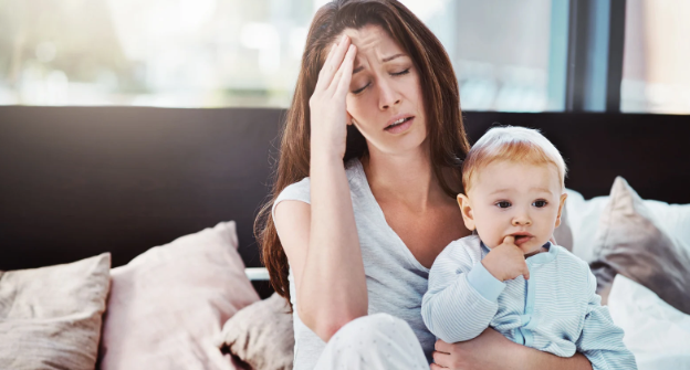 young mom, stressed mom, baby, mom and baby, baby in bed, tired mom