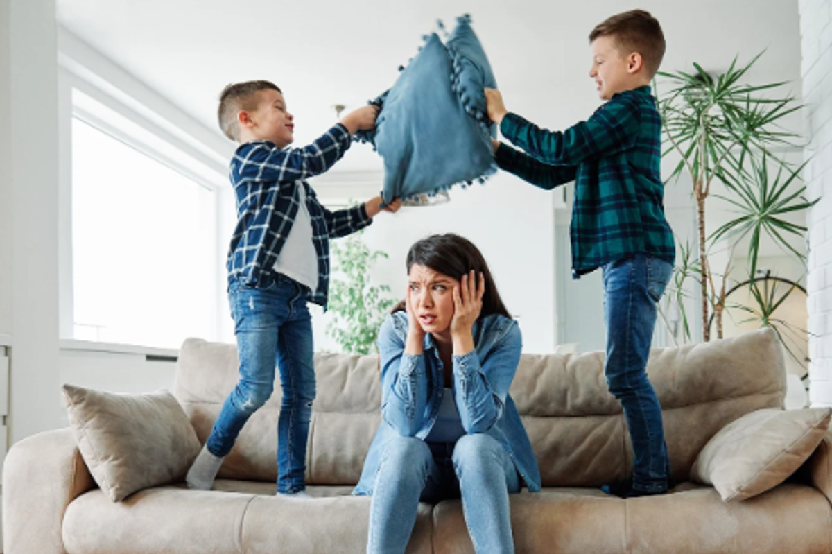 parenting, moms, stressed mom, pillow fight, standing on couch, kids playing,