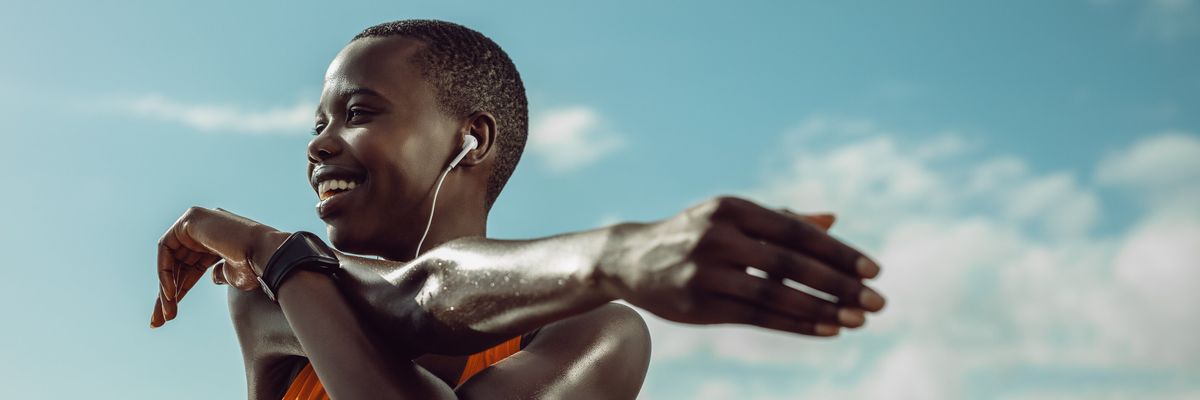 Black woman stretching at the beach during a morning workout during The Great Lock In reset