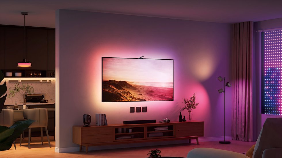 photo of Govee TV Backlight 3 Pro on a TV on the wall in an entertainment room with lights off