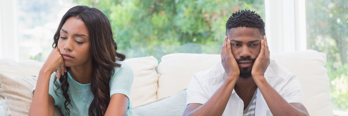 Couple having argument on the couch at home in the living room